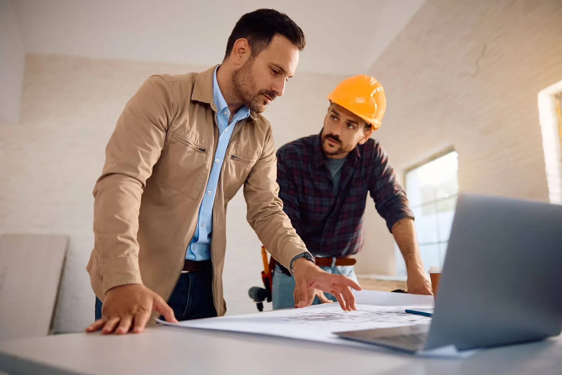 Contractor and designer reviewing construction plans on site